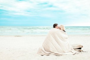 Жених и невеста под одеялом на пляже